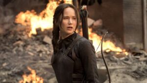 Katniss Everdeen, protagonista de Jogos Vorazes, em cena com seu arco e flecha